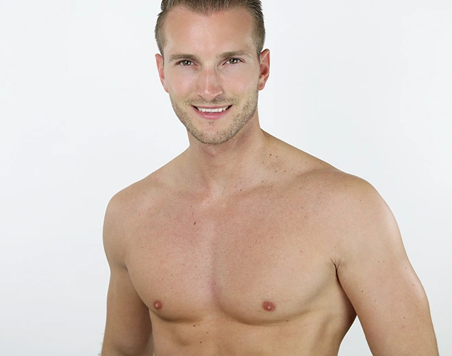 Smiling man showing toned chest after male body contouring or gynecomastia surgery