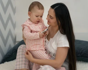 Mother holding baby at home, symbolising body changes after pregnancy and suitability for mummy makeover surgery
